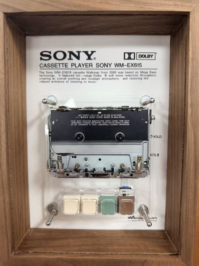 Sony Walkman WM-EX1 mounted inside a solid wood frame with a cassette displayed beneath it