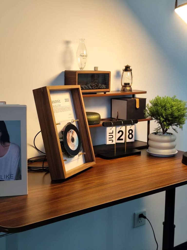 Two framed vintage players displayed on a shelf with a lamp and a vintage flip clock