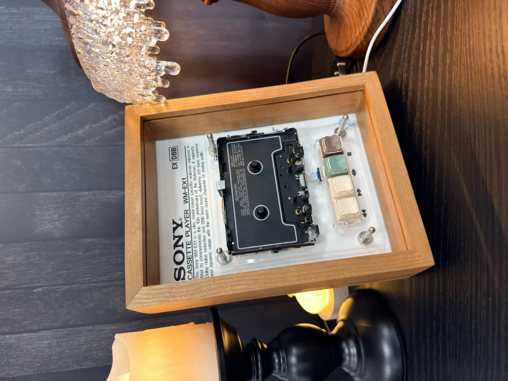 Sony Walkman WM-EX1 in a dark wood frame photographed against a dark background